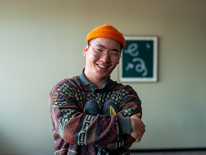 En smilende mann med oransje lue og briller