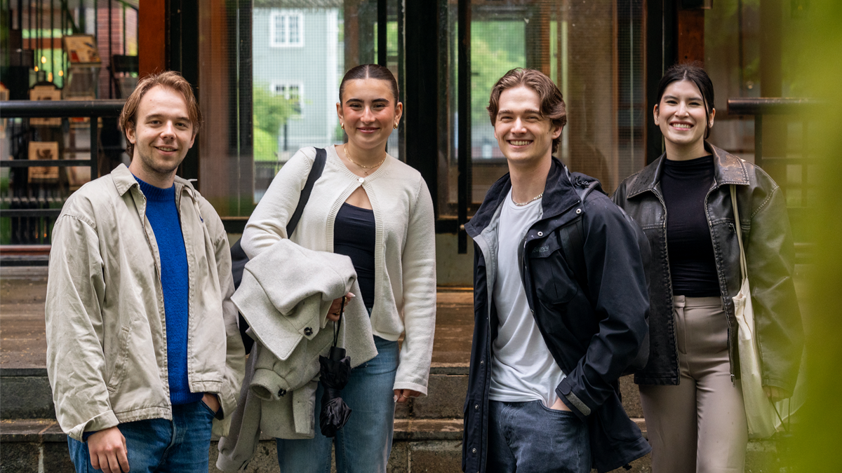 fire smilende studenter foran inngangen til Harriet Holters hus