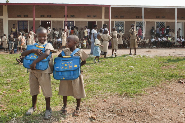 To skolebarn med blå sekker i Burundi.