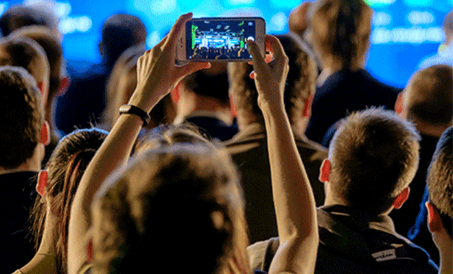Person filmer en konsert med mobilen.